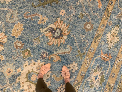 Woman standing on a blue & green Kars Turkish area rug with a featured motif.