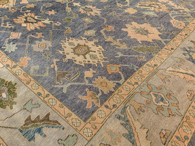 Corner of a blue & green Oushak Turkish area rug.