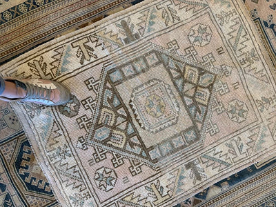 Woman's foot on a small brown and grey Sivas Turkish rug.