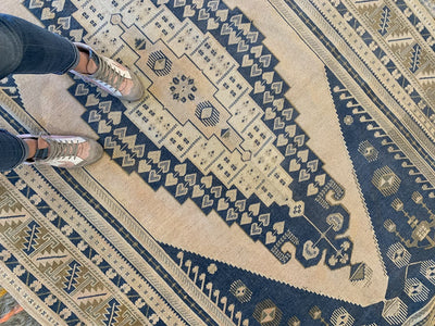 Woman standing on a blue & green extra large Sivas Turkish Rug.