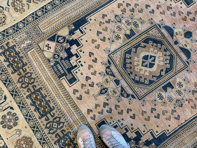 Woman's feet on a blue & green extra large Sivas Turkish Rug.