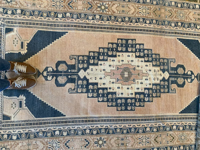 Woman standing on a blue & green extra large Sivas Turkish Rug.