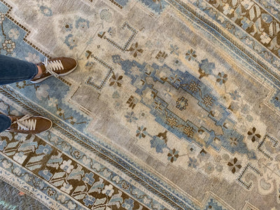 Woman standing on a blue & green extra large Sivas Turkish Rug.
