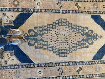 Woman standing on a blue & green large Sivas Turkish Rug.
