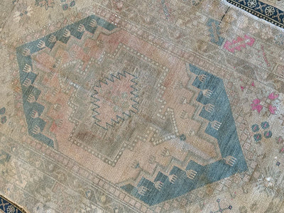 Central medallion on an antique blue & green medium Bor Turkish Rug.