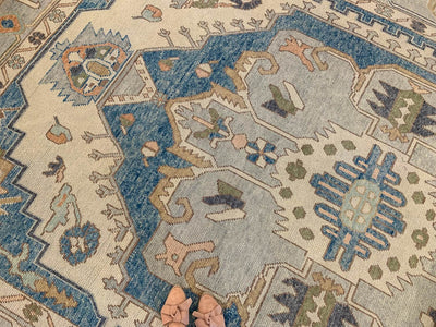 Tan leander slides on a blue & green Oushak Turkish area rug.