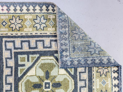 Underside of a corner on a blue & green Oushak Turkish runner.