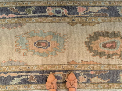 Tan leather flats on a blue & green Turkish runner rug.