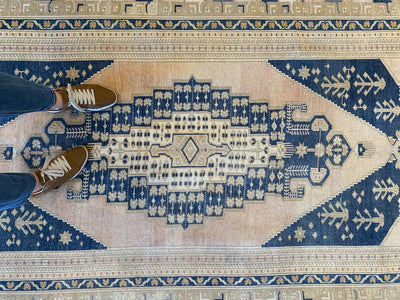 Woman standing on a blue & green Sivas Turkish Rug runner.
