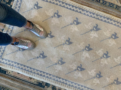 Woman standing on a blue & green small Sivas Turkish Rug.