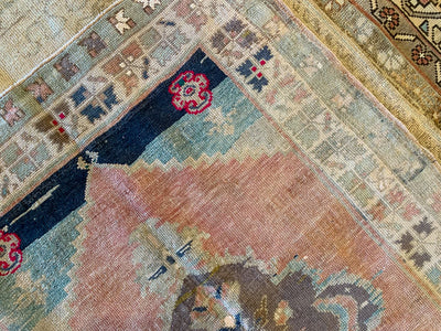 Close up of hand knotting on a small blue & green Sivas Turkish rug.