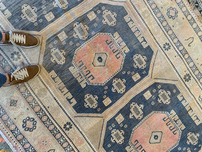 Woman standing on a brown & grey large Sivas Turkish Rug.