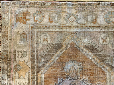 Close up of fading hand knotting on a vintage medium red & orange Bor Turkish rug.