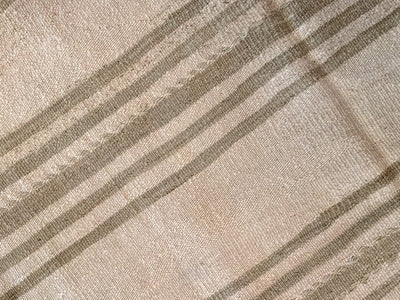 Close up of hand knotting on a brown & grey Turkish rug runner.