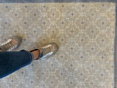 Woman standing on a brown & grey small Sivas Turkish Rug.