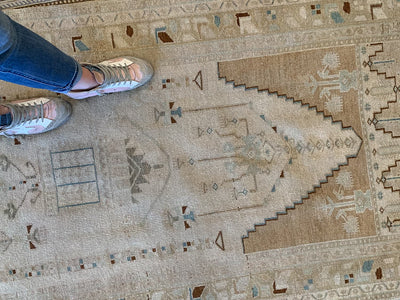 Woman standing on a brown & grey small Sivas Turkish Rug.