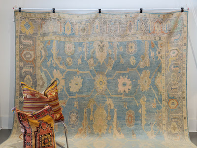 Hanging extra large blue & green Turkish Oushak rug.