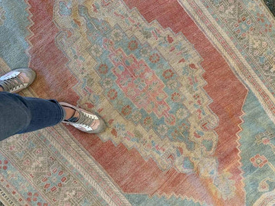 Woman's feet on an extra large red & orange Sivas Turkish Rug.