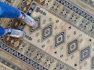 Woman's feet on medium blue & green Sivas Turkish Rug.