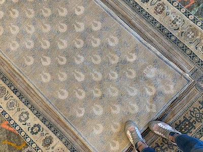 Woman's feet on a medium brown and grey Sivas Turkish rug.