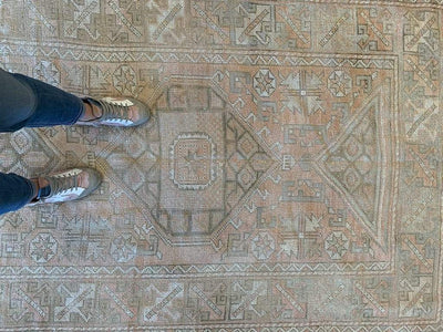 Womans feet on a medium brown and grey Sivas Turkish rug.