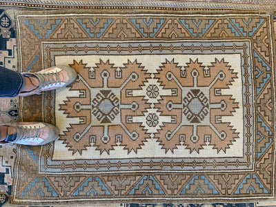 Woman standing on a extra small red & orange Kars Turkish Rug.