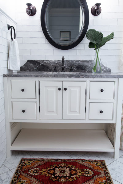 A red & orange extra small Turkish Yastik Rug in a modern bathroom.