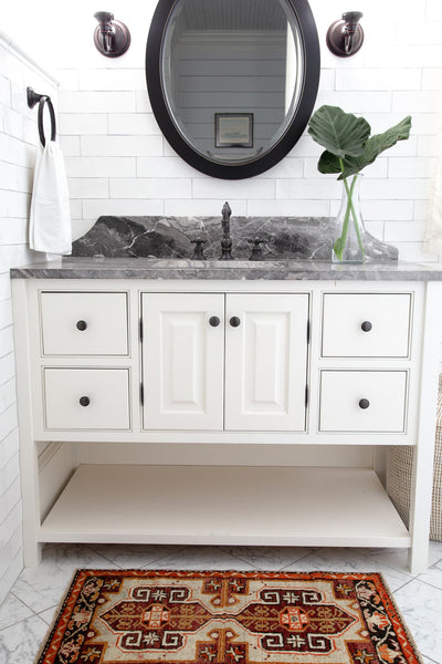 A red & orange extra small Turkish Yastik Rug in a modern bathroom