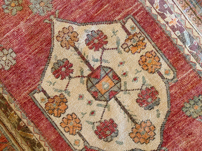 Central medallion on a small red & orange Cal Turkish rug.
