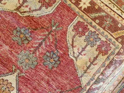 Close up of hand knotting work on a small red & orange Cal Turkish rug.
