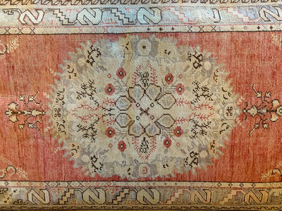 Central medallion on a medium red & orange Guney Turkish rug.