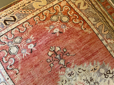 Close up of medallion and hand knotting on a medium red & orange Guney Turkish rug.