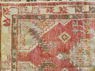 Corner of a small red & orange Cal Turkish rug.