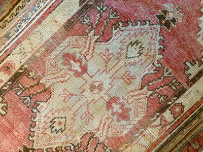 Central medallion on a small red & orange Cal Turkish rug.