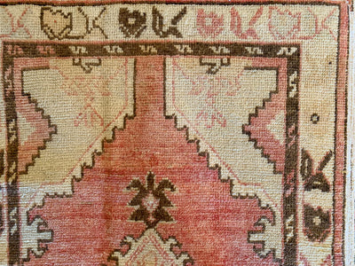 Corner hand knotting on a small red & orange Cal Turkish rug.