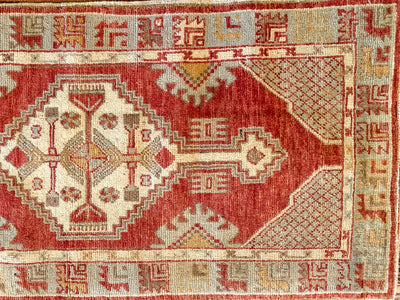 A small red & orange Cal Turkish rug.