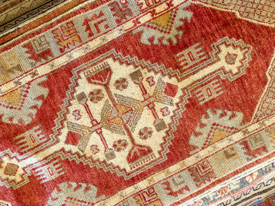 Central medallion on a small red & orange Cal Turkish rug.