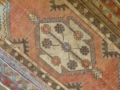 Central medallion on a small red & orange Cal Turkish rug.