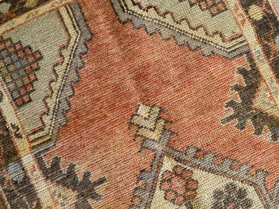 Close up on hand knotting on a small red & orange Cal Turkish rug.