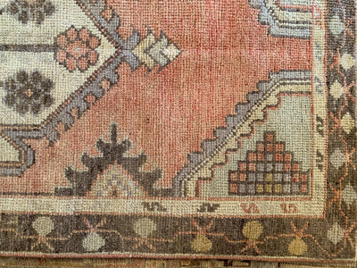 Close up of hand knotting on a small red & orange Cal Turkish rug.