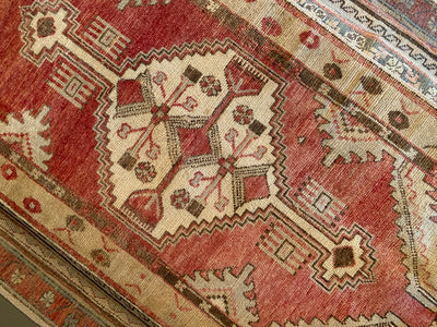 Central medallion on a small red & orange Cal Turkish rug.
