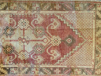 Close up of hand knotting on a small red & orange Cal Turkish rug.