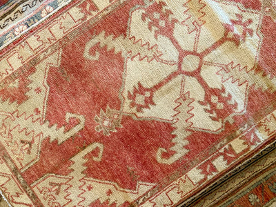Central medallion on a small red & orange Cal Turkish rug.