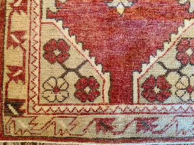 Close up of knotting work on a small red & orange Cal Turkish rug.