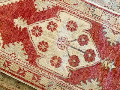Central medallion on a small red & orange Cal Turkish rug.