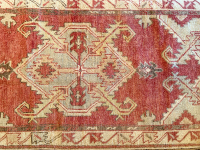Central medallion on a small red & orange Cal Turkish rug.