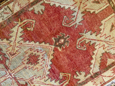 Close up of hand knotting on a small red & orange Cal Turkish rug.