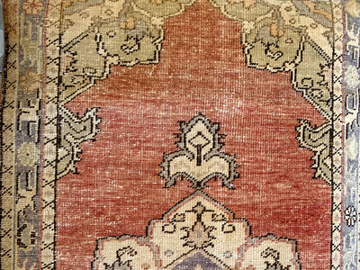 Close up of hand knotting on a small red & orange Guney Turkish rug.