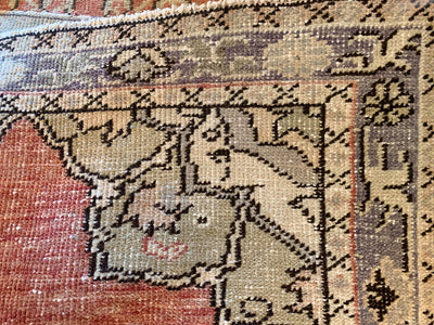 Close up of hand knotting on a small red & orange Guney Turkish rug.