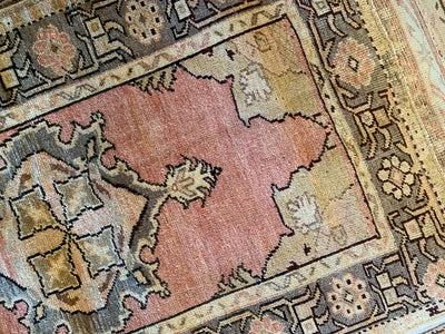 Hand knotting on a small red & orange Guney Turkish rug.